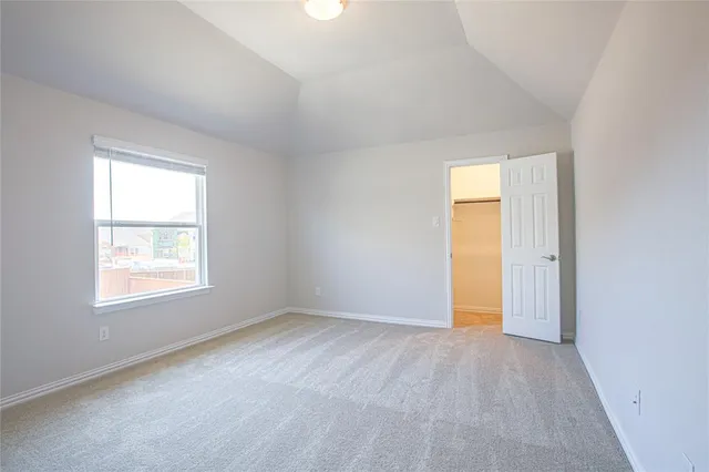 an empty room with a window and wooden floor