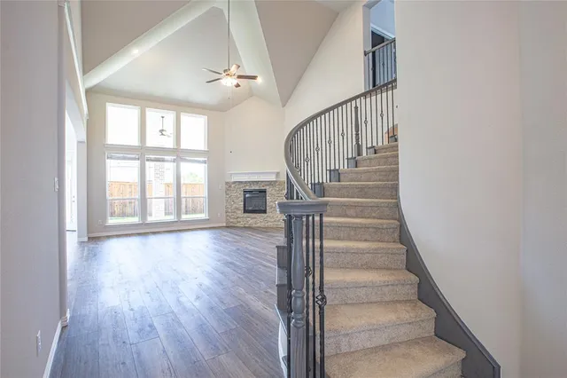 a view of staircase with wooden floor and fan