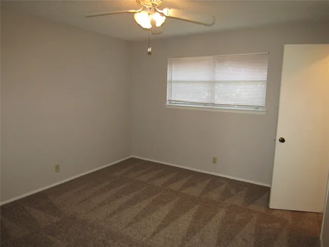 an empty room with a chandelier fan