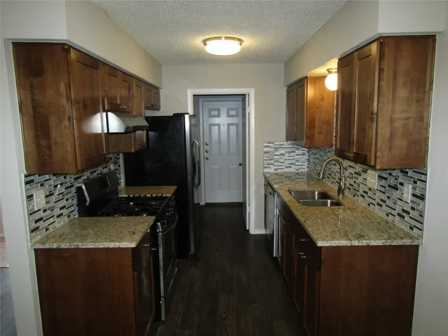 a kitchen with a sink stove and refrigerator