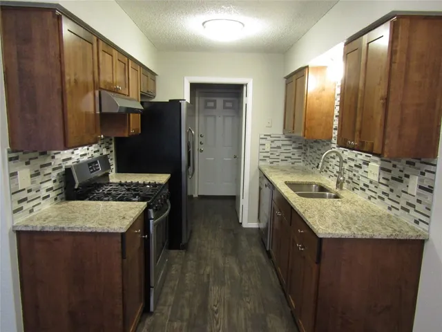 a kitchen with stainless steel appliances granite countertop a sink stove and refrigerator