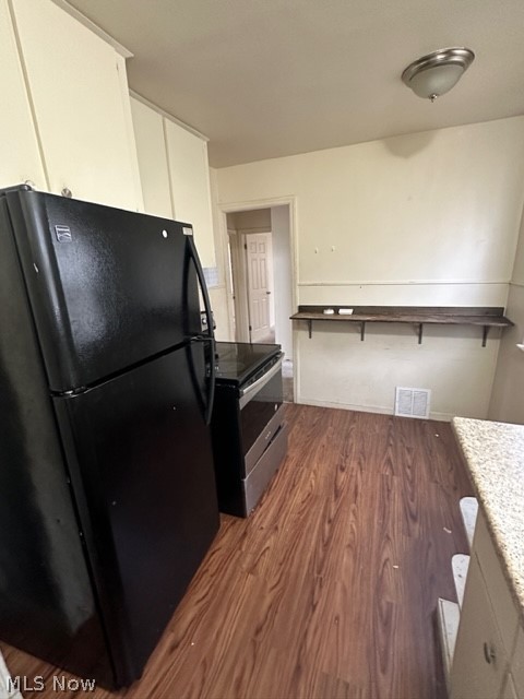 21400 Watson Road Maple Heights, OH 44137 - Photo 5 of 24 Kitchen with white cabinets, black fridge, stainless steel electric range oven, and dark hardwood / wood-style floors