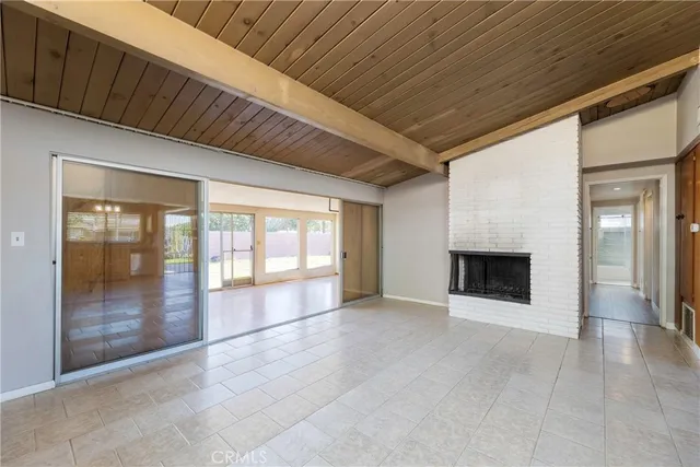 a view of an empty room with a fireplace and a window