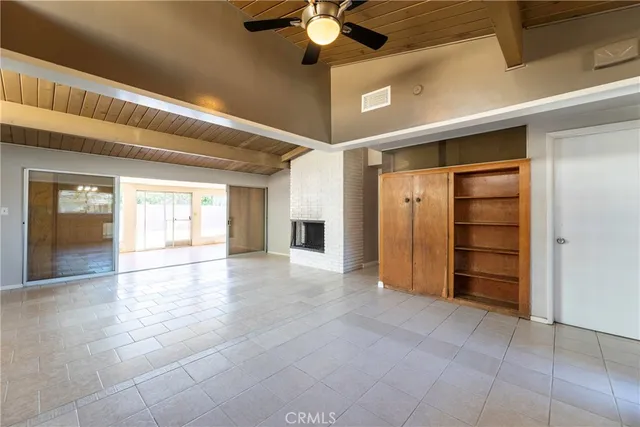a view of an empty room with a window and fire place