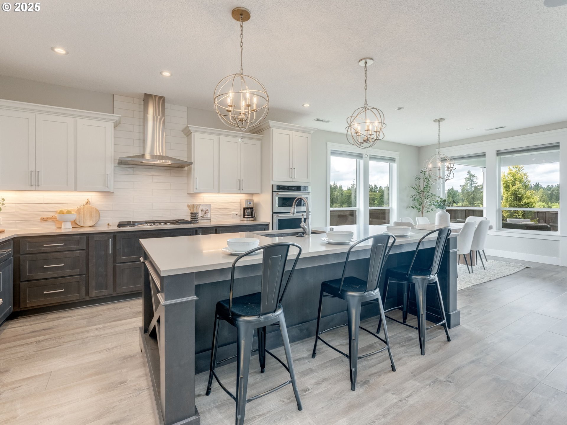 1703 South Farm View Loop Ridgefield, WA 98642 - Photo 6 of 22 a kitchen with stainless steel appliances granite countertop wooden floor cabinets dining table and chairs