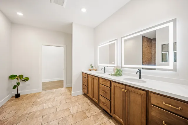 a spacious bathroom with a double vanity sink and a mirror