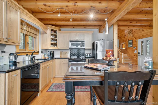 a kitchen with stainless steel appliances granite countertop a stove a sink dishwasher and cabinets with wooden floor