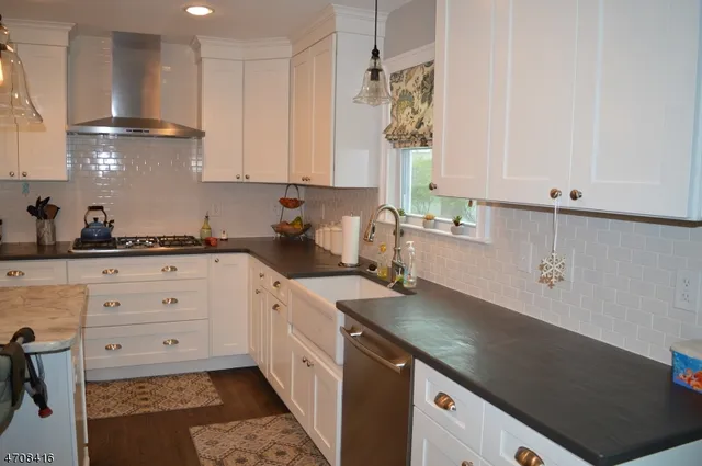 a kitchen with granite countertop a sink a stove and cabinets