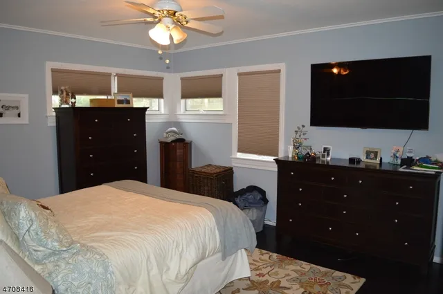 a bedroom with a bed and a flat tv screen on dresser