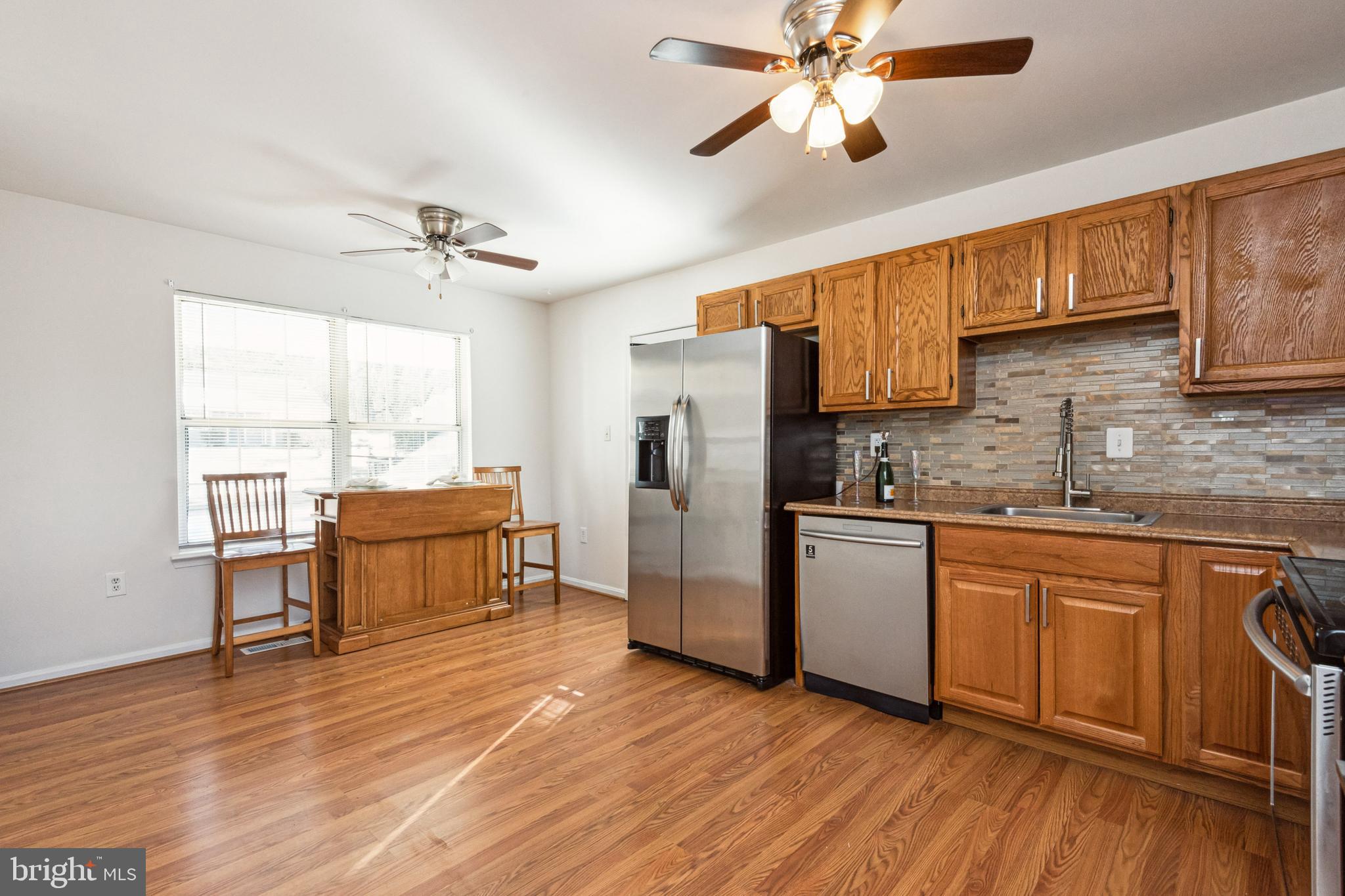 7419 Bentree Road Fort Washington, MD 20744 - Photo 11 of 31 a kitchen with stainless steel appliances a stove a sink dishwasher and a refrigerator with wooden floor