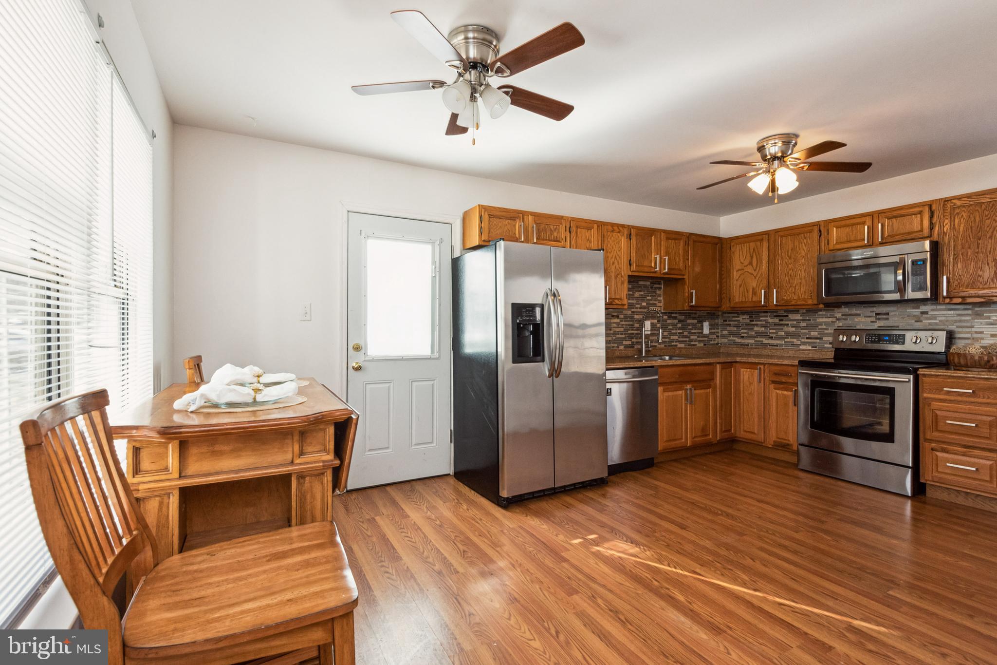 7419 Bentree Road Fort Washington, MD 20744 - Photo 9 of 31 a kitchen with stainless steel appliances wooden floor and a refrigerator