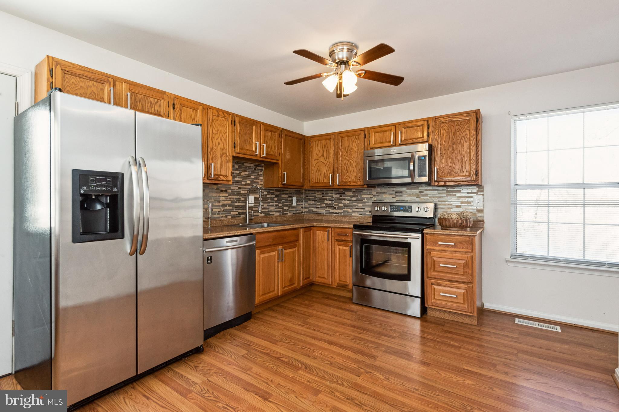 7419 Bentree Road Fort Washington, MD 20744 - Photo 10 of 31 a kitchen with granite countertop a refrigerator stove top oven and sink