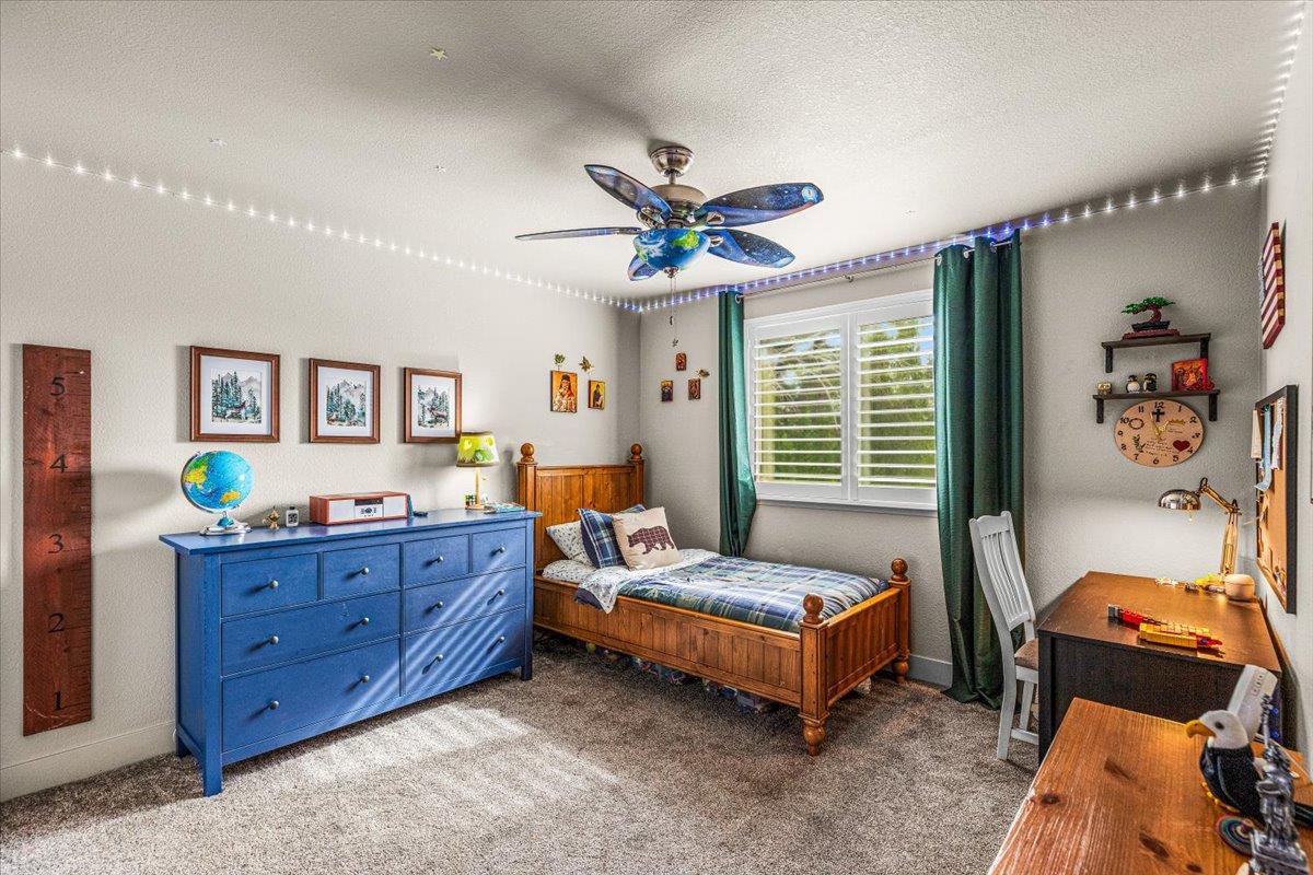 2485 Tigers Drive Turlock, CA 95382 - Photo 55 of 77 a spacious bedroom with a bed and a chandelier