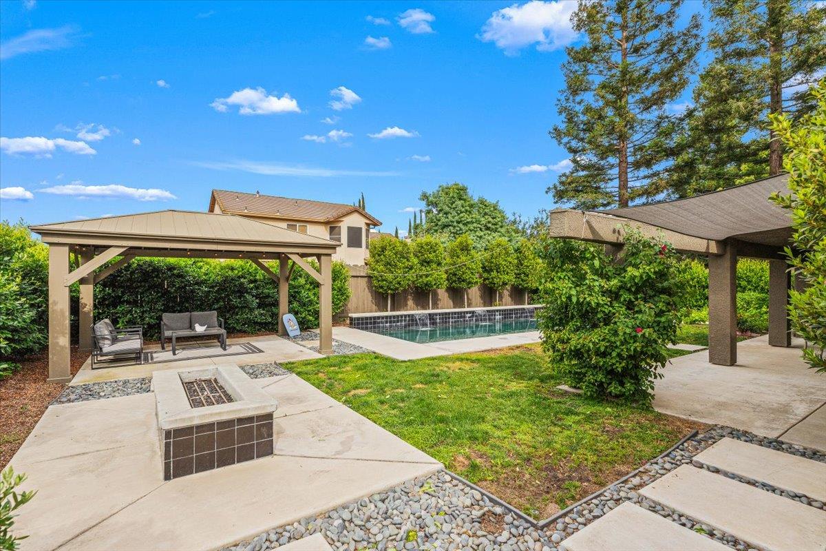 2485 Tigers Drive Turlock, CA 95382 - Photo 75 of 77 a view of a patio with a table and chairs under an umbrella with a small yard