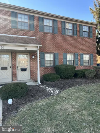 a view of a brick house next to a yard