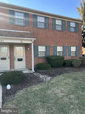 a view of a brick house next to a yard