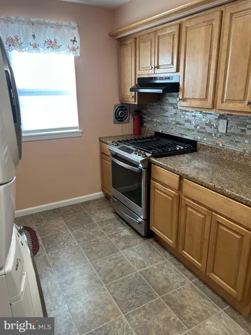 a kitchen with granite countertop a stove a sink and a microwave
