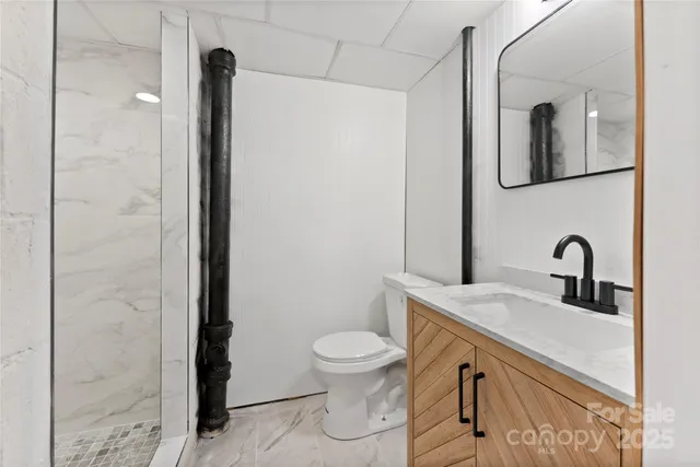 a bathroom with a sink a toilet and shower