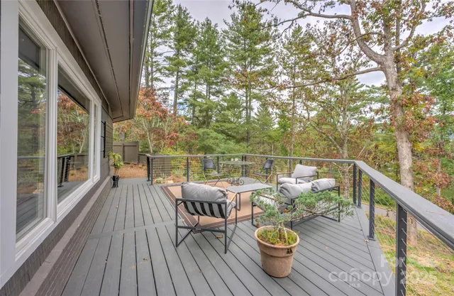 a view of a deck with furniture and trees