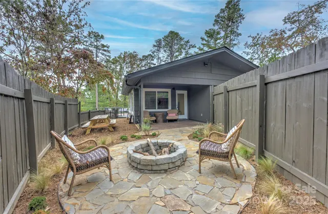 a view of a patio with table and chairs and wooden fence