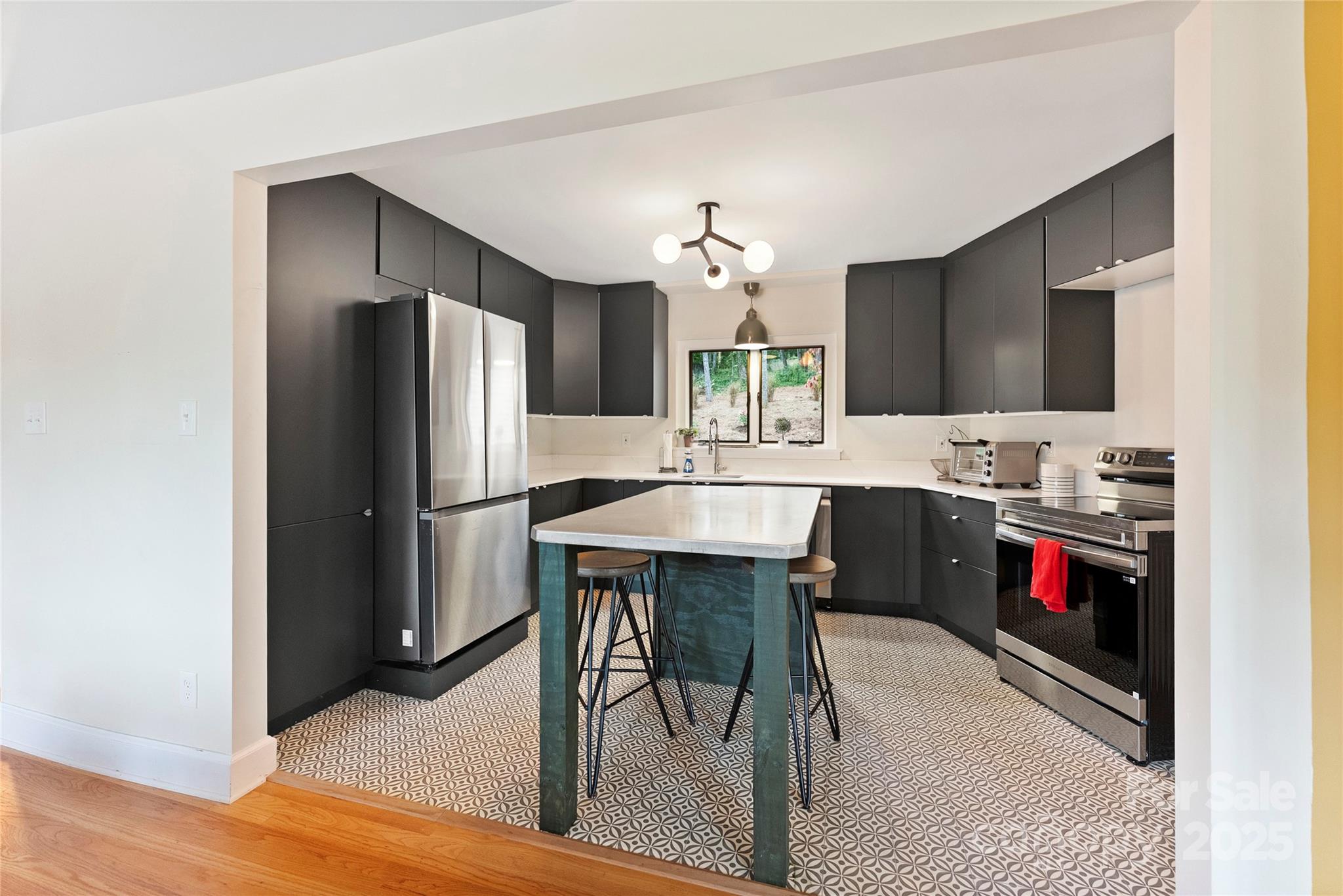 351 Windsor Road Asheville, NC 28804 - Photo 7 of 42 a kitchen with stainless steel appliances kitchen island granite countertop a refrigerator a stove a sink and a dining table with wooden floor