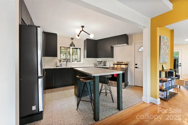 a kitchen with kitchen island a dining table and chairs