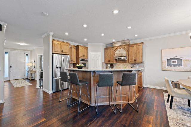 6208 West Bull River Road Highland, UT 84003 - Photo 21 of 90 Open-concept kitchen featuring wood-finish flooring, recessed lighting, and a breakfast bar with stone countertops