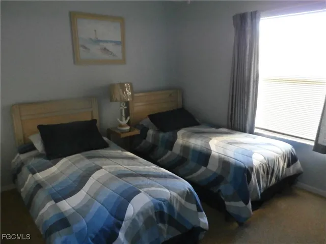 a bedroom with two beds and a window