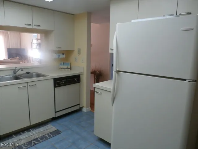 a kitchen with a sink a refrigerator and cabinets