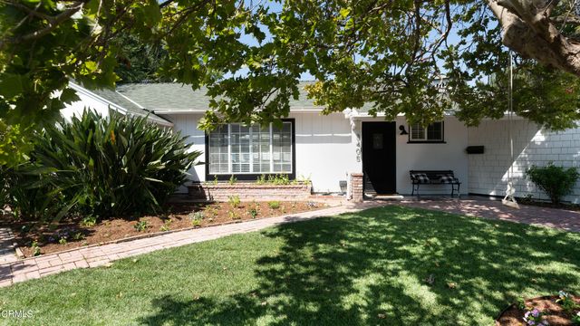 a view of a house with a tree and a yard