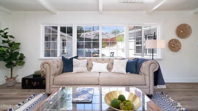 a living room with furniture a rug and a window