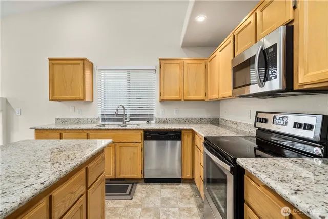 a kitchen with stainless steel appliances granite countertop a sink stove and cabinets