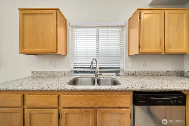 a kitchen with granite countertop cabinets sink and window