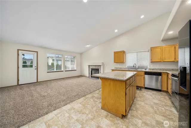 a view of kitchen with stainless steel appliances granite countertop refrigerator sink and stove