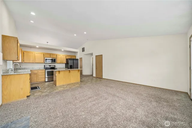 a large kitchen with cabinets and a refrigerator