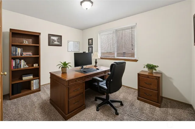 a view of a workspace with furniture and a window