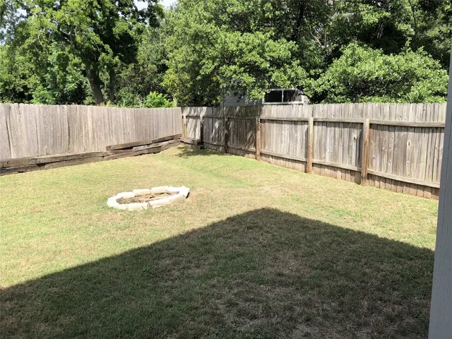 a view of a house with a yard and wooden fence