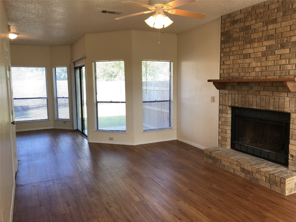 8300 Bradford Edward Cove, Unit B Austin, TX 78759 - Photo 2 of 15 an empty room with wooden floor fireplace and windows