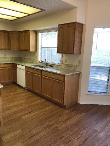 a kitchen with stainless steel appliances granite countertop a sink and wooden cabinets