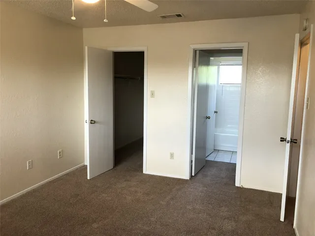 an empty room with closet and a bathroom
