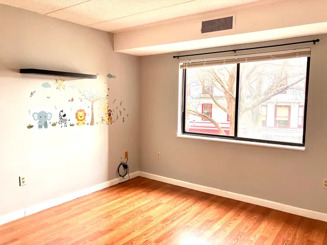 a view of empty room with wooden floor