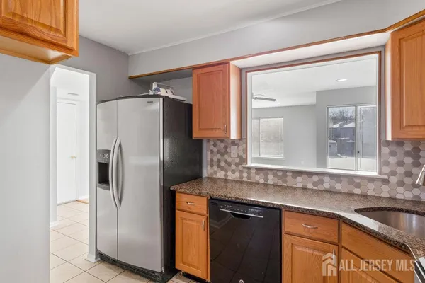 a kitchen with granite countertop a refrigerator and a sink