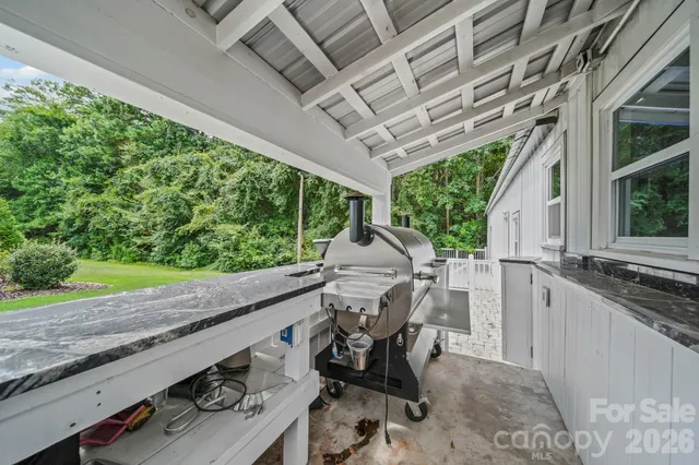 a view of a patio with table and chairs with wooden floor and fence