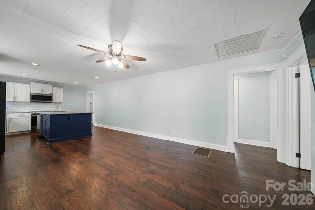 a view of kitchen with sink microwave and cabinets