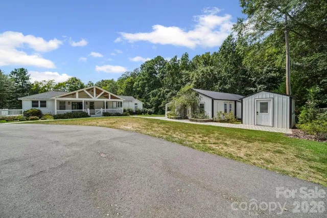 a white house with a big yard and large trees