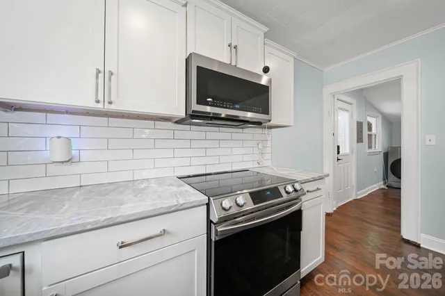 a kitchen with granite countertop a stove and a wooden floor