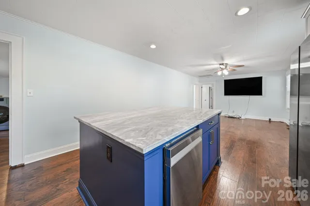 a kitchen with a center island and wooden floor