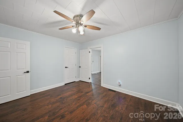 a view of an empty room with wooden floor