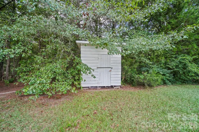 an aerial view of a house with a yard and large trees