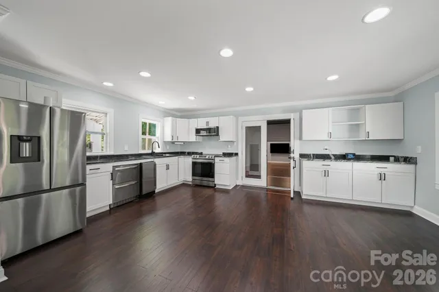 a kitchen with stainless steel appliances a refrigerator and wooden floor